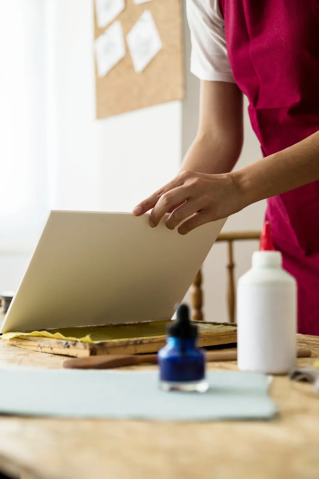 Vinilo recién cortado y muestras de color impresas sobre la mesa de un taller de rotulación