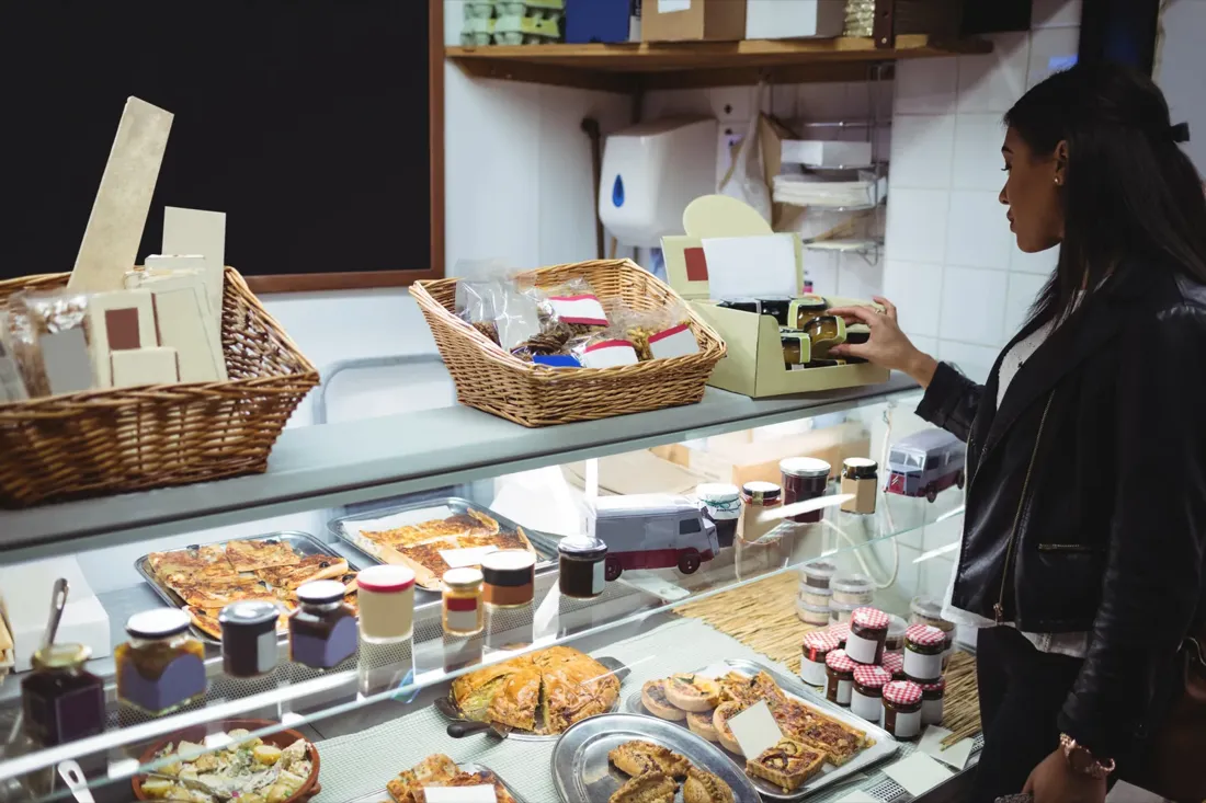 Interior de una panadería de barrio a primera hora, con el pan recién colocado en las estanterías