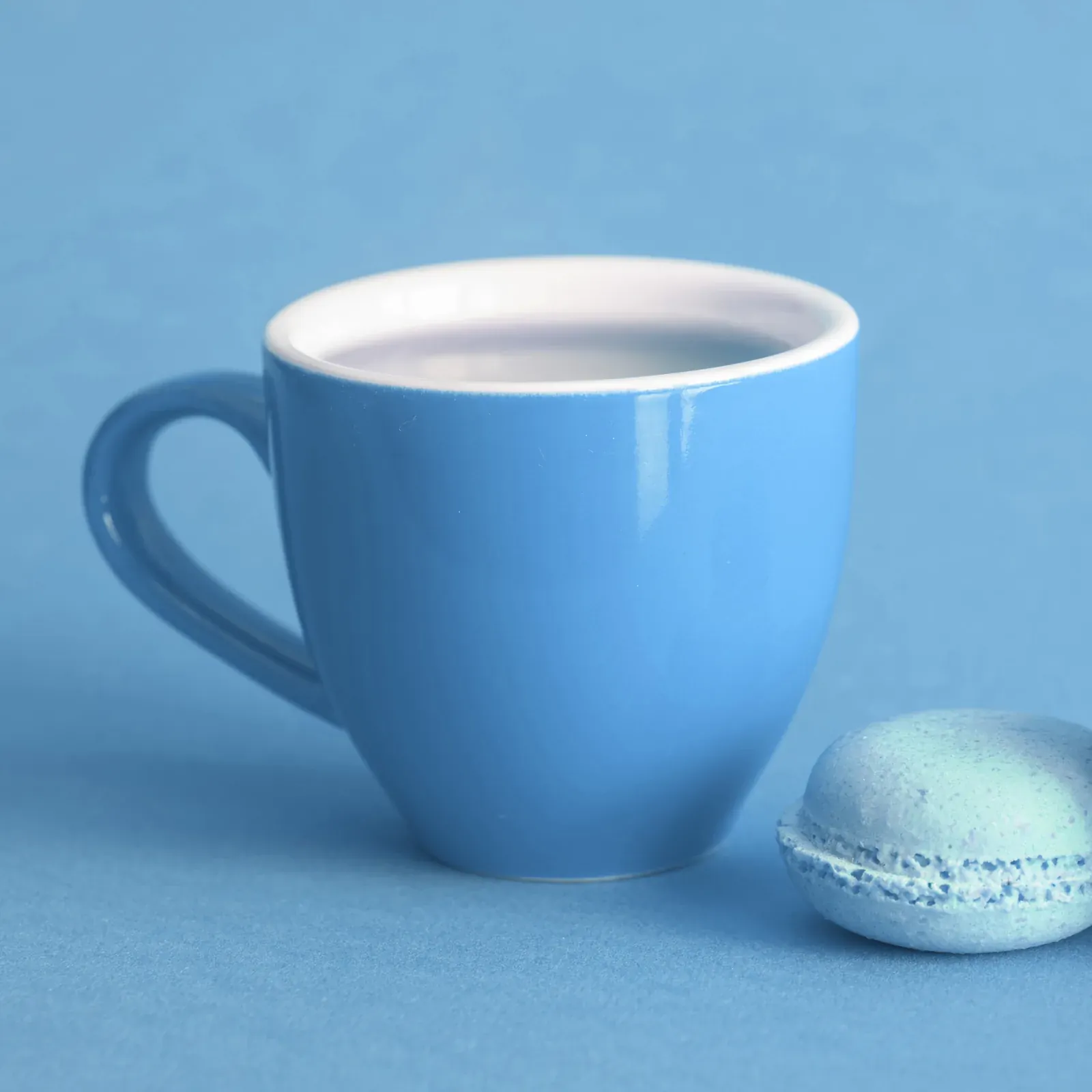 Taza de cerámica azul sobre una mesa de madera clara