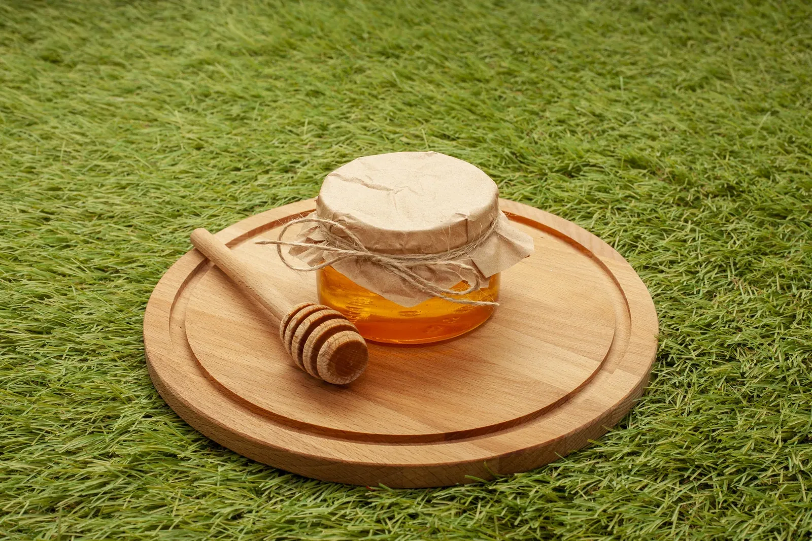 Tarro de miel con cucharilla de madera fotografiado en formato cuadrado