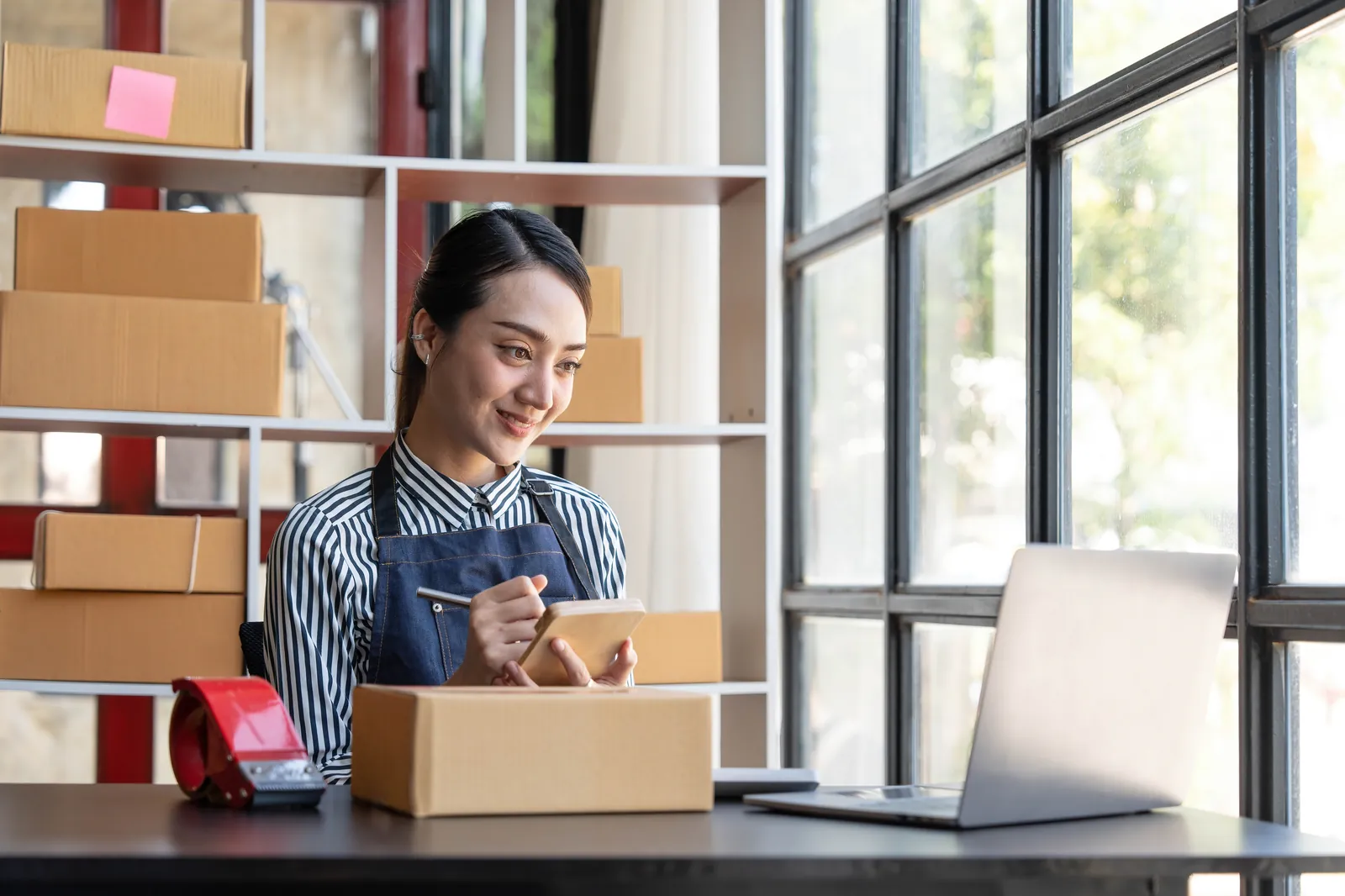 La dueña de una tienda online prepara sus pedidos en el mostrador
