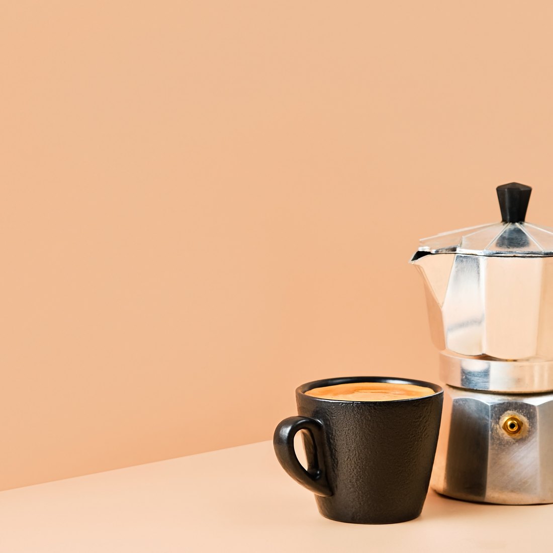 Una cafetera y una taza de café